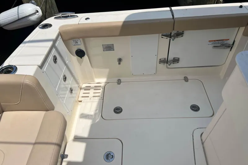 Slide: The Image of 2021 Scout 305 LXF boat interior with beige seating and storage compartments. - 17