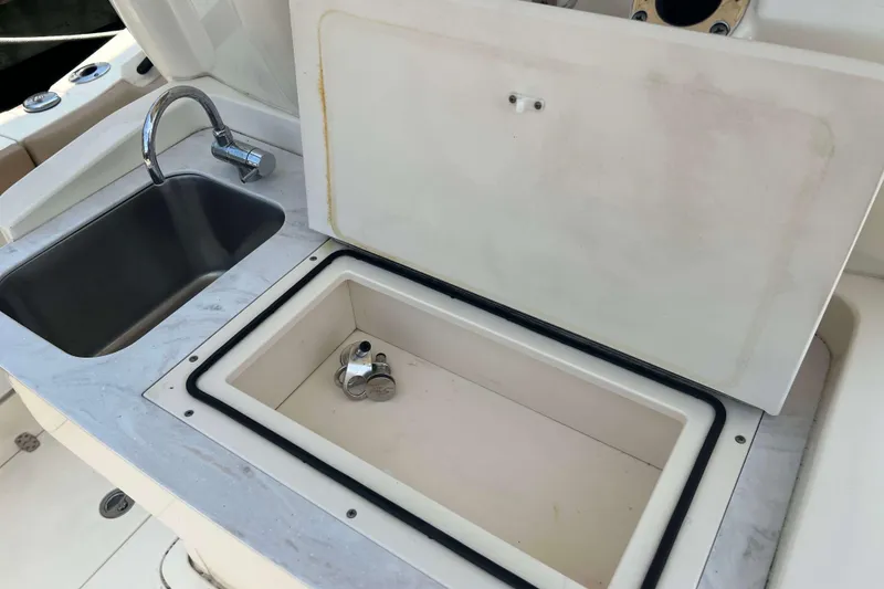 Slide: The Image of 2021 Scout 305 LXF boat sink and storage compartment detail. - 25