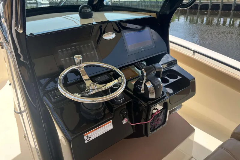 Slide: The Image of 2021 Scout 305 LXF boat dashboard with steering wheel and controls. - 27