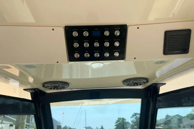 Slide: The Image of Control panel and speakers inside a 2021 Scout 305 LXF boat. - 32