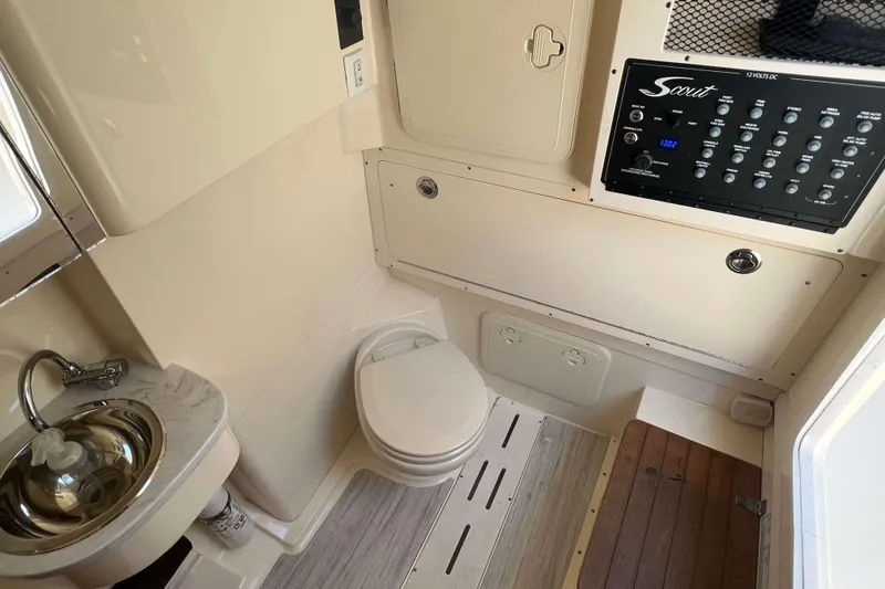 Slide: The Image of 2021 Scout 305 LXF boat interior with sink, toilet, and control panel. - 38