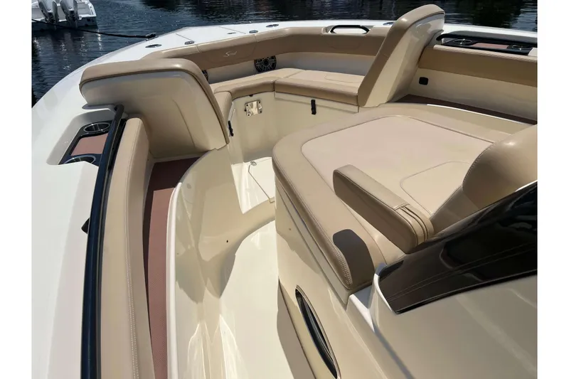 Slide: The Image of 2021 Scout 305 LXF boat interior with beige seating and cup holders. - 49