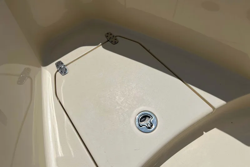 Slide: The Image of 2021 Scout 305 LXF boat storage compartment with metal latch and hinges. - 57
