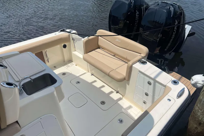 Slide: The Image of 2021 Scout 305 LXF boat interior with seating, sink, and dual Mercury engines. - 6