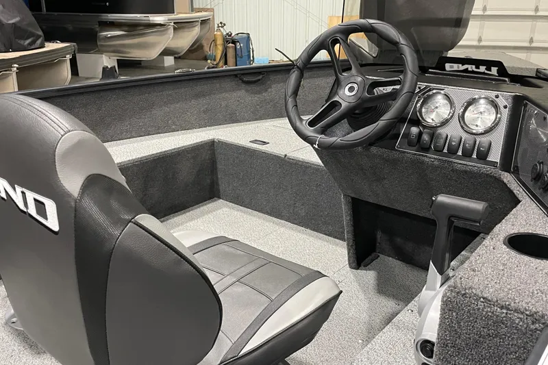 Slide: The Image of 2026 Lund 1650 Rebel XL SS boat interior with steering wheel and dashboard controls. - 2