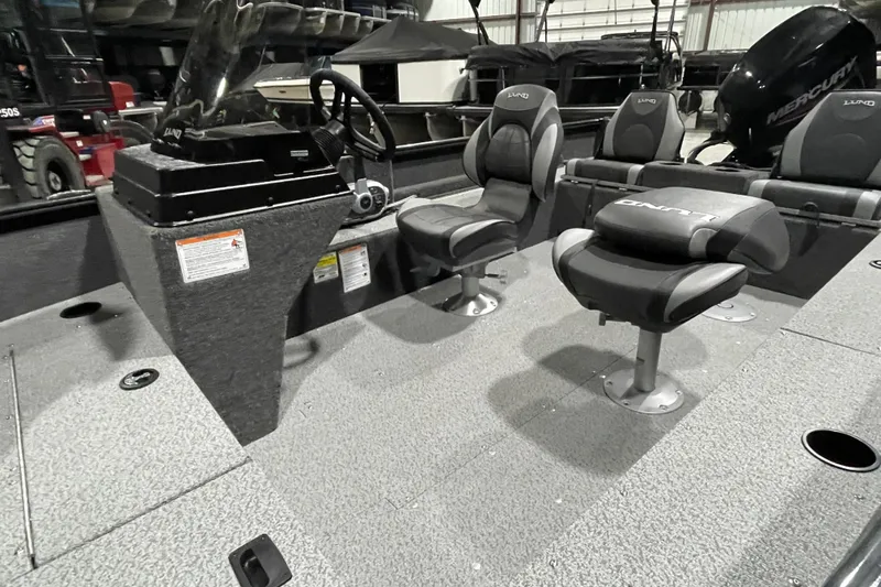 Slide: The Image of 2026 Lund 1650 Rebel XL SS boat interior with seating and steering console. - 4