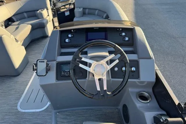 Slide: The Image of 2022 Bennington 23LFB boat dashboard with steering wheel and seating area. - 12