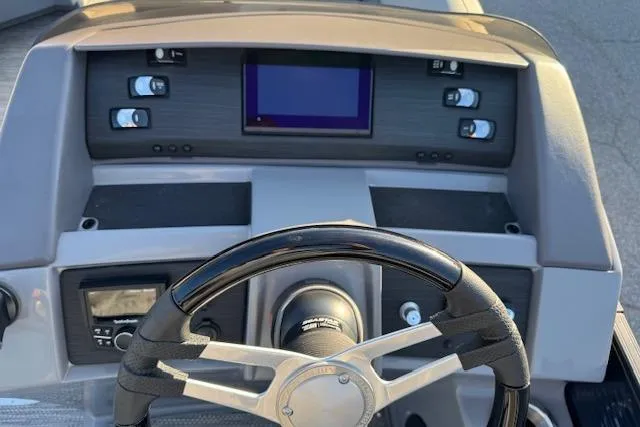 Slide: The Image of 2022 Bennington 23LFB boat dashboard with steering wheel and control panel. - 13