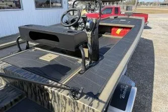 Slide: The Image of 2026 Gator Tail 2060 EXTREME C.C. boat with camouflage design, parked near a red vehicle. - 3