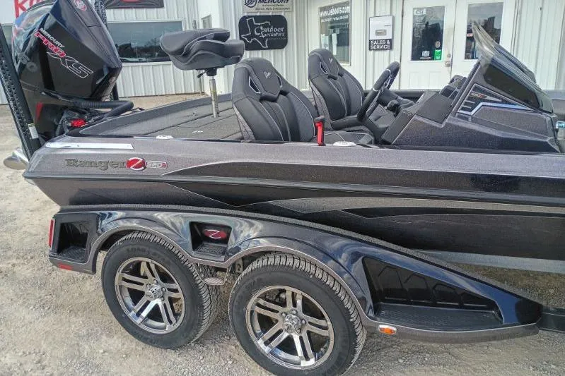 Slide: The Image of 2022 Ranger Z520R boat with dual axle trailer, parked outside a dealership. - 2