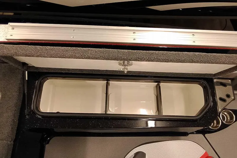 Slide: The Image of 2026 Ranger 621FS Fisherman boat storage compartment with open lid and cup holders. - 25