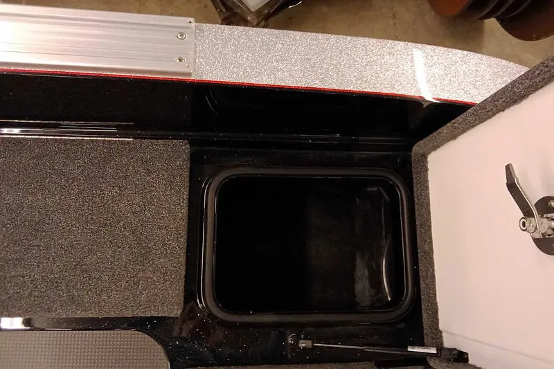 Slide: The Image of 2026 Ranger 621FS Fisherman boat storage compartment with open hatch and carpeted interior. - 28