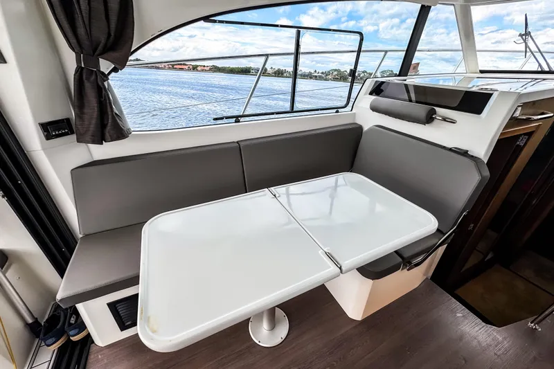 Slide: The Image of Interior of 2022 Beneteau Antares 11 Fly with dining area and scenic window view. - 11
