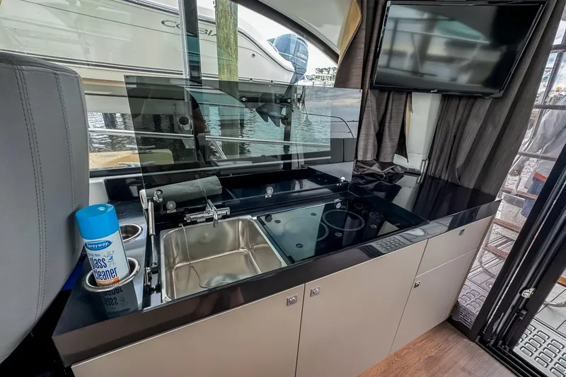 Slide: The Image of Interior of 2022 Beneteau Antares 11 Fly with kitchenette and TV, docked by water. - 15