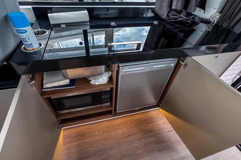 Slide: The Image of Modern kitchen area in 2022 Beneteau Antares 11 Fly yacht with appliances and storage. - 17