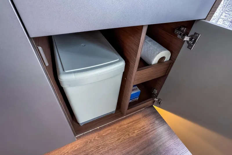 Slide: The Image of Cabinet storage in 2022 Beneteau Antares 11 Fly, featuring trash bin and paper towel. - 19