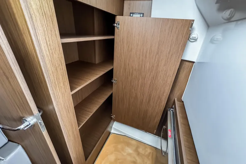 Slide: The Image of Interior storage cabinet on 2022 Beneteau Antares 11 Fly boat, featuring wooden shelves. - 28