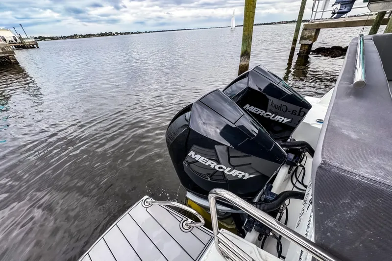 Slide: The Image of 2022 Beneteau Antares 11 Fly with dual Mercury outboard engines on a calm waterfront. - 4