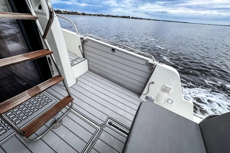 Slide: The Image of Beneteau Antares 11 Fly 2022 boat deck with wooden steps and ocean view. - 7