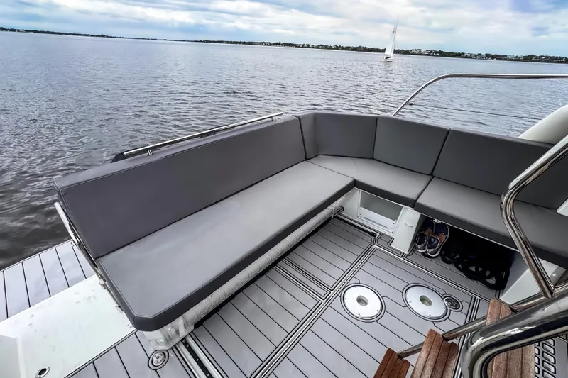 Slide: The Image of Beneteau Antares 11 Fly 2022 boat deck with gray seating and scenic water view. - 8
