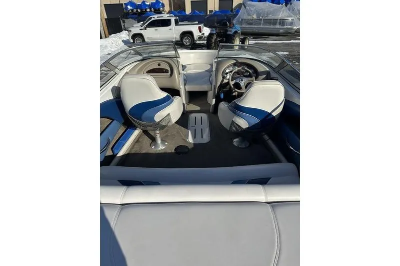 Slide: The Image of 2000 Ebbtide 210 Bow Rider interior with blue and white seating, steering wheel, and dashboard. - 8