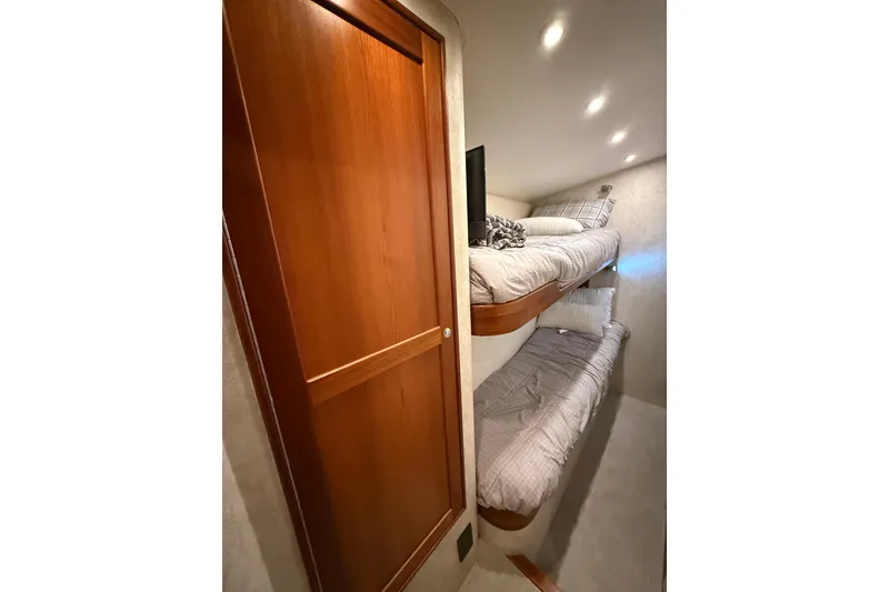 Slide: The Image of Interior of 2006 Blackwell 66 Convertible with cozy bunk beds and wooden door. - 18