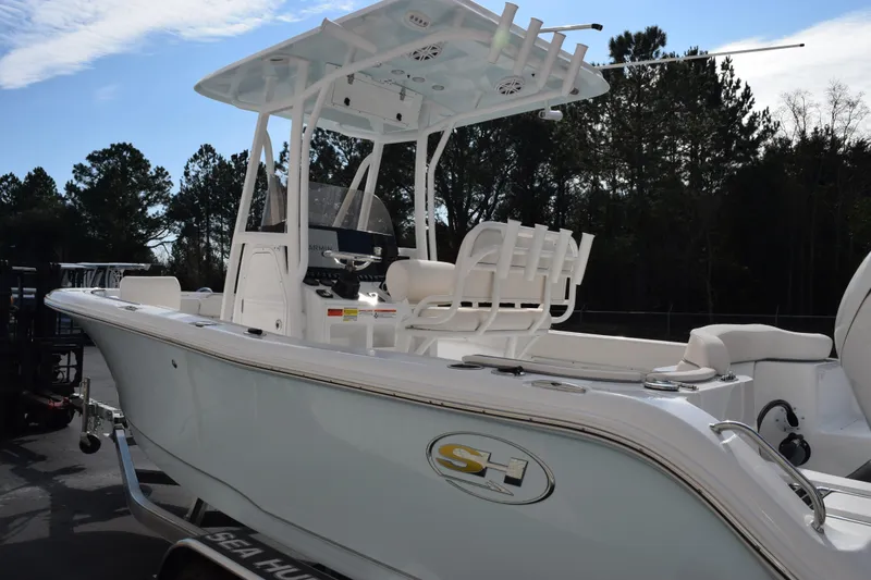 Slide: The Image of 2026 Sea Hunt Ultra 219 boat with T-top and seating, parked outdoors. - 7