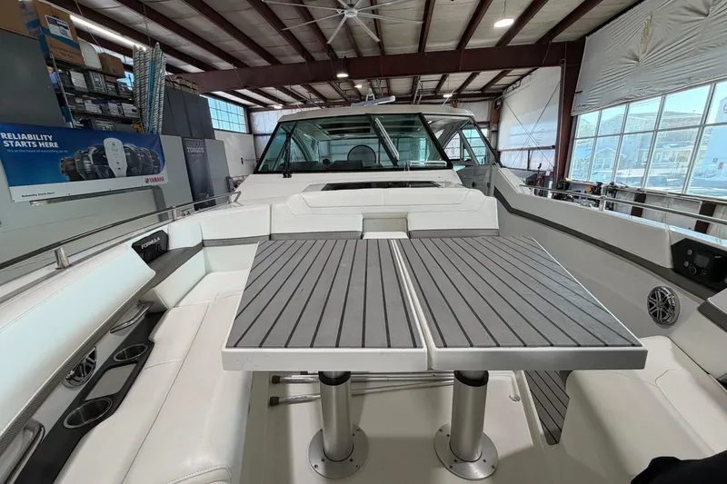Slide: The Image of 2017 Formula 430 Super Sport Crossover boat interior with seating and table in a showroom. - 39