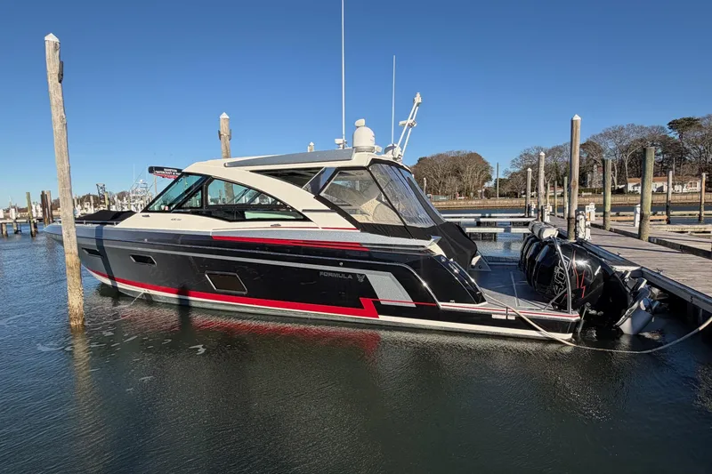 Slide: The Image of 2017 Formula 430 Super Sport Crossover boat docked in a marina under clear blue skies. - 42