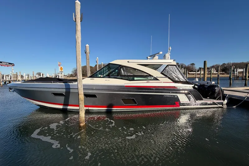 Slide: The Image of 2017 Formula 430 Super Sport Crossover boat docked in a marina under clear blue skies. - 43