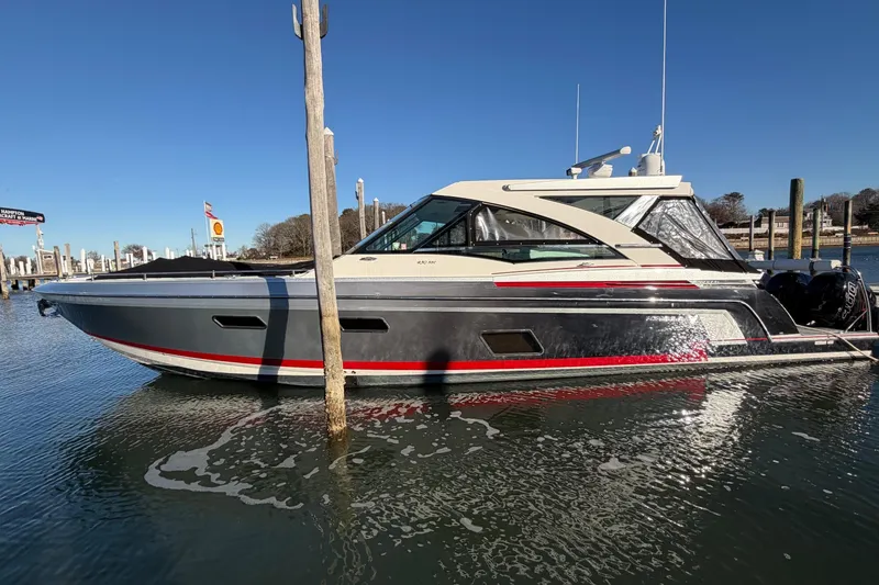 Slide: The Image of 2017 Formula 430 Super Sport Crossover boat docked in marina under clear blue sky. - 44