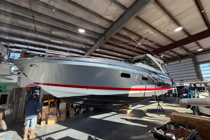 Slide: The Image of 2017 Formula 430 Super Sport Crossover boat in a warehouse, elevated for maintenance. - 47