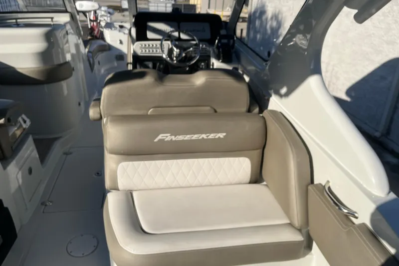 Slide: The Image of 2022 Finseeker 280 DC boat interior with cushioned seating and steering console. - 13