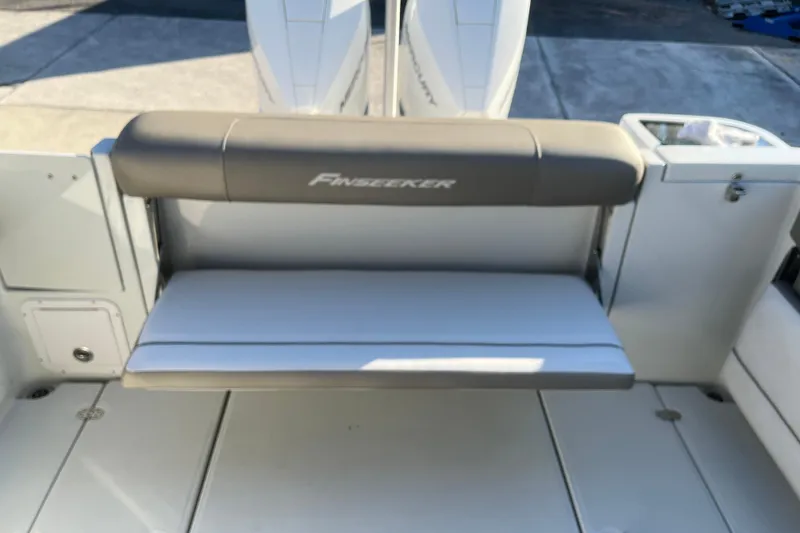 Slide: The Image of 2022 Finseeker 280 DC boat with cushioned seating and storage compartments. - 15