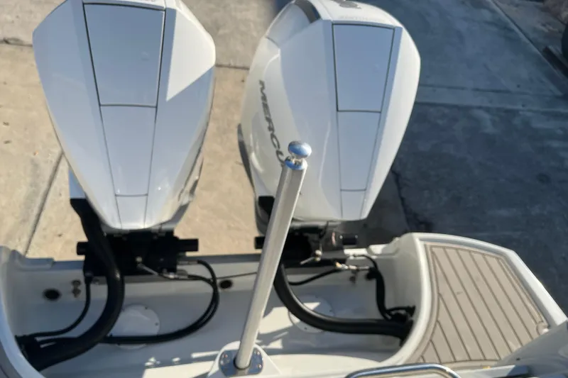 Slide: The Image of 2022 Finseeker 280 DC boat with dual Mercury outboard engines, docked on concrete. - 19