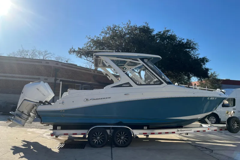 Slide: The Image of 2022 Finseeker 280 DC boat on trailer, sunny day, outdoor setting. - 20