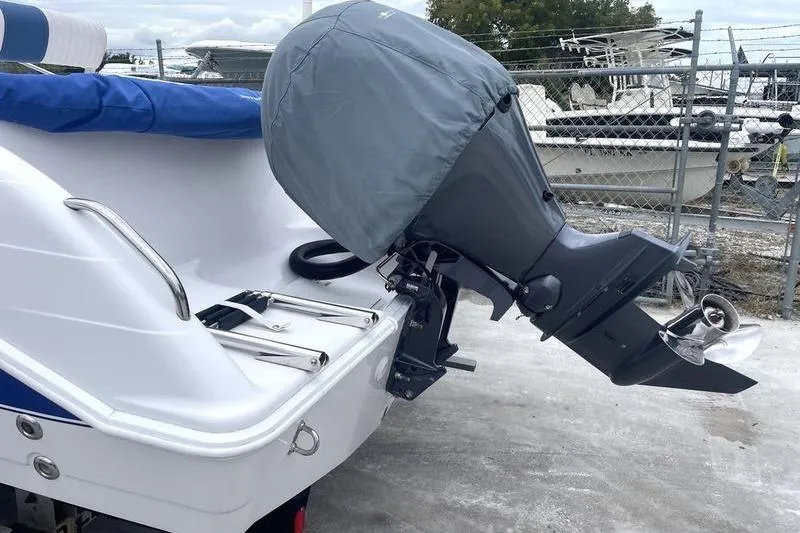 Slide: The Image of 2002 Pro-Line 19 Sport boat with covered outboard motor in a marina setting. - 1