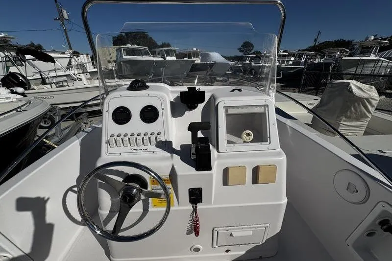 Slide: The Image of 2002 Pro-Line 19 Sport boat dashboard with steering wheel and controls. - 11
