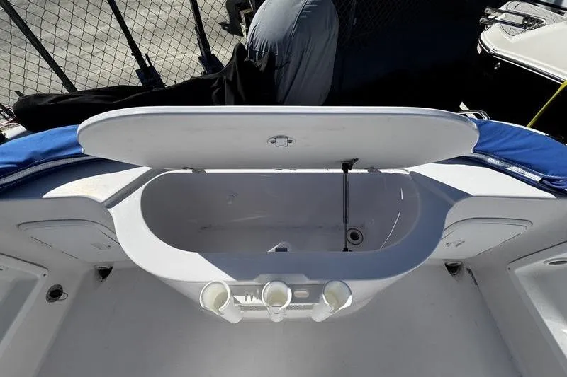 Slide: The Image of Open storage compartment on a 2002 Pro-Line 19 Sport boat, featuring rod holders. - 15