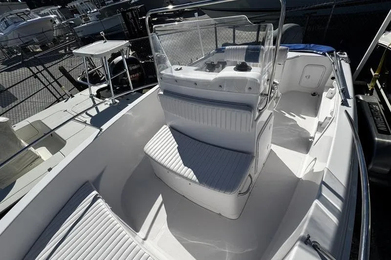Slide: The Image of 2002 Pro-Line 19 Sport boat interior with seating and console, docked in marina. - 5