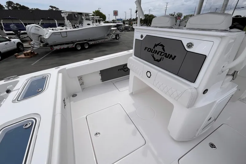 Slide: The Image of 2025 Fountain 34 Tournament Edition boat interior with seating and storage, parked in a dealership lot. - 8