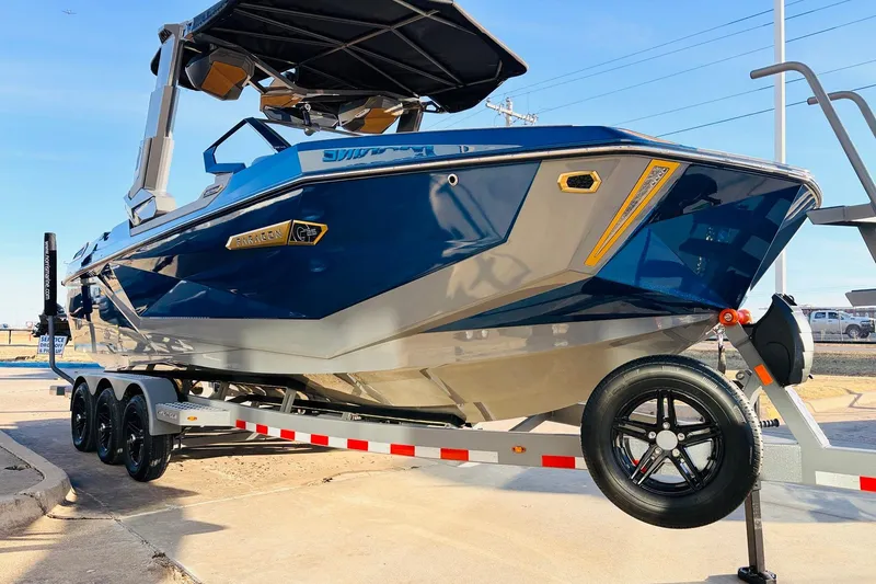 Slide: The Image of 2026 Nautique Super Air Nautique G25 Paragon boat on trailer, blue and silver design. - 4