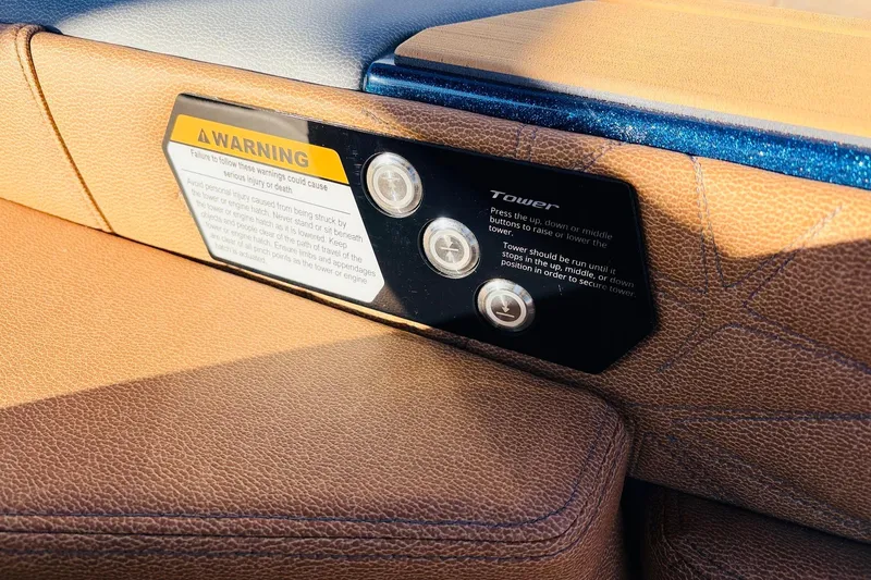 Slide: The Image of 2026 Nautique Super Air Nautique G25 Paragon interior with warning label and control buttons. - 78