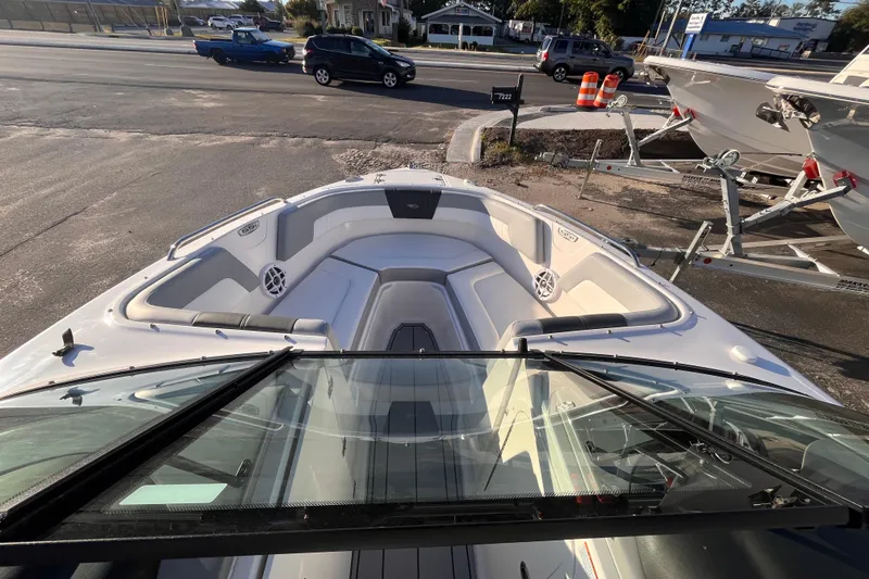 Slide: The Image of 2025 Chaparral 23 SSi OB boat interior with seating and speakers, parked on a trailer. - 8