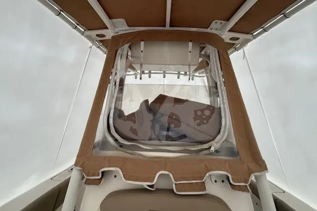 Slide: The Image of 2020 Pioneer 202 Islander boat with tan canopy and clear window enclosure. - 11