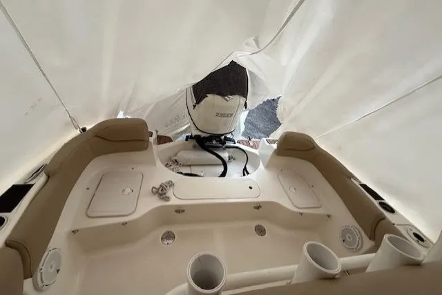 Slide: The Image of 2020 Pioneer 202 Islander boat interior under cover, showcasing seating and motor. - 13