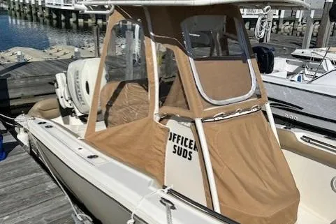 Slide: The Image of 2020 Pioneer 202 Islander boat docked with tan canopy and "Office Suds" text. - 3