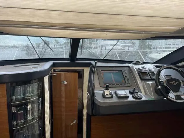 Slide: The Image of Interior helm of 2008 Marquis 40 SC yacht with navigation controls and glass cabinet. - 16