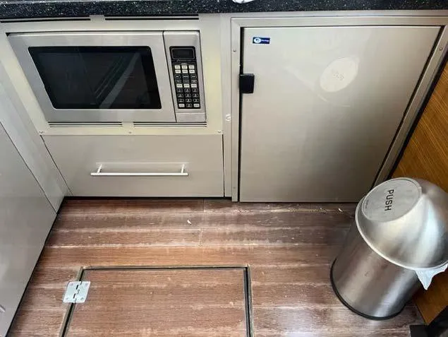 Slide: The Image of 2008 Marquis 40 SC yacht kitchen with microwave, cabinet, and trash bin. - 37
