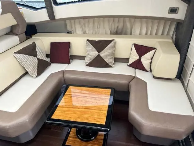 Slide: The Image of Luxurious interior seating of 2008 Marquis 40 SC yacht with decorative pillows and wooden table. - 40